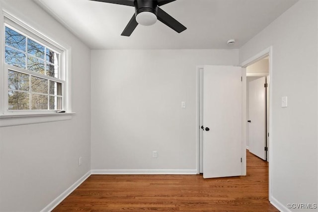 unfurnished bedroom with wood finished floors, ceiling fan, and baseboards