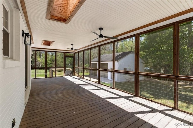 unfurnished sunroom featuring a ceiling fan