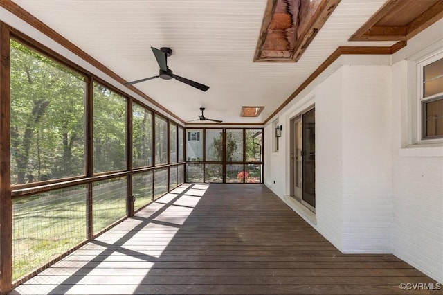 unfurnished sunroom with a ceiling fan and a wealth of natural light
