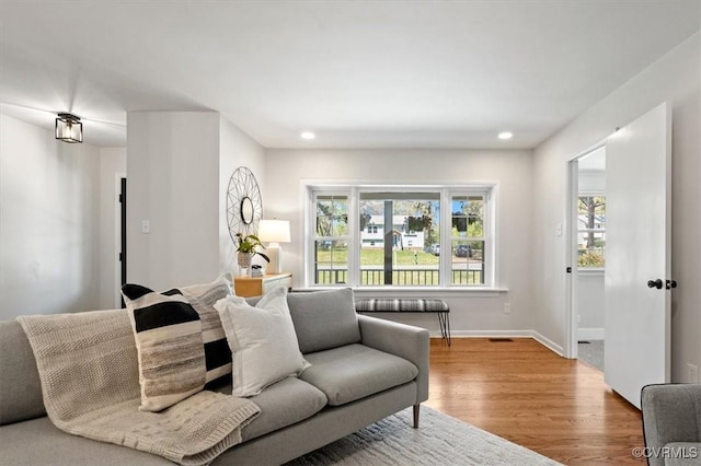 living area featuring recessed lighting, baseboards, and wood finished floors