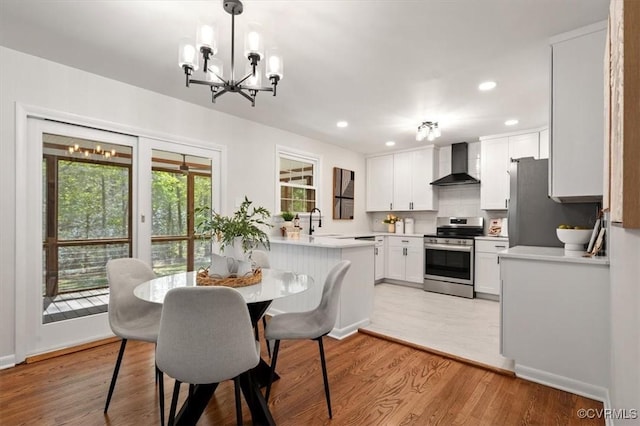 dining room with a chandelier, light wood finished floors, and recessed lighting