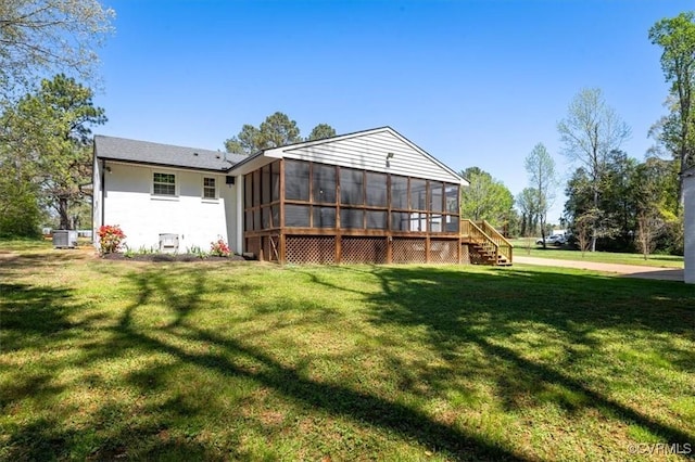 back of house featuring a yard and a sunroom