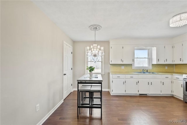 2407 Crawley Rd, Cullen, VA 23924 - kitchen with light countertops, white cabinetry, a sink, dark wood-style floors, and an inviting chandelier