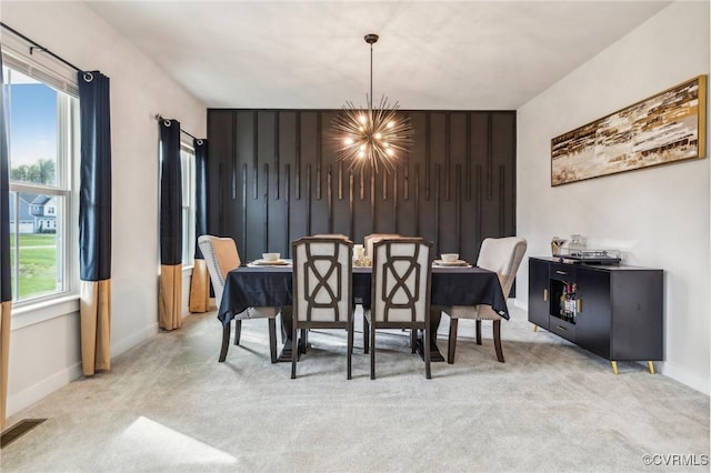 carpeted dining space featuring baseboards, a notable chandelier, and visible vents