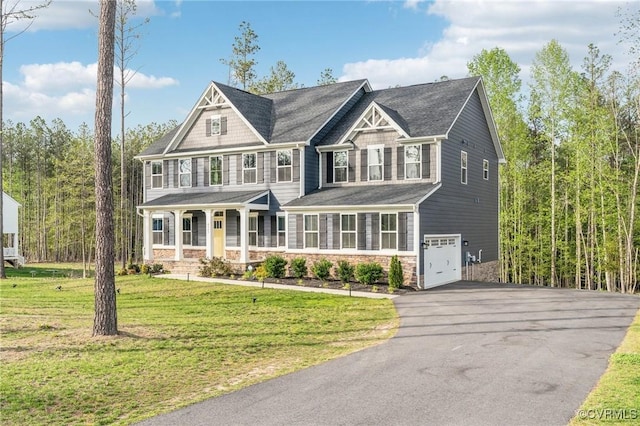 view of front facade with aphalt driveway, covered porch, stone siding, a front yard, and a garage