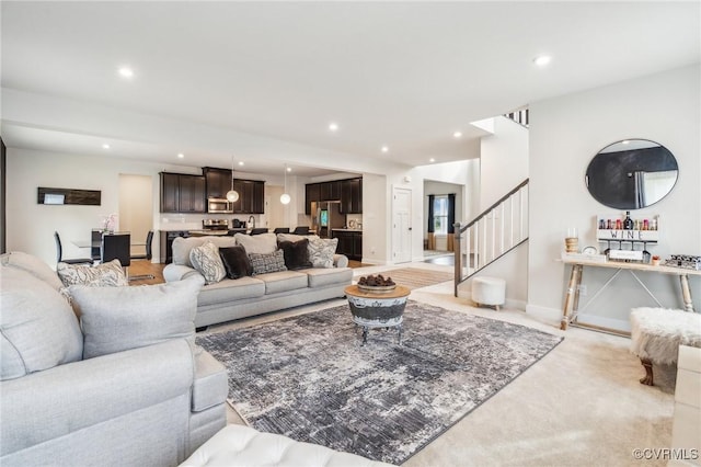 living room with stairway, baseboards, light carpet, and recessed lighting