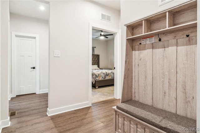 mudroom with wood finished floors, visible vents, baseboards, and ceiling fan
