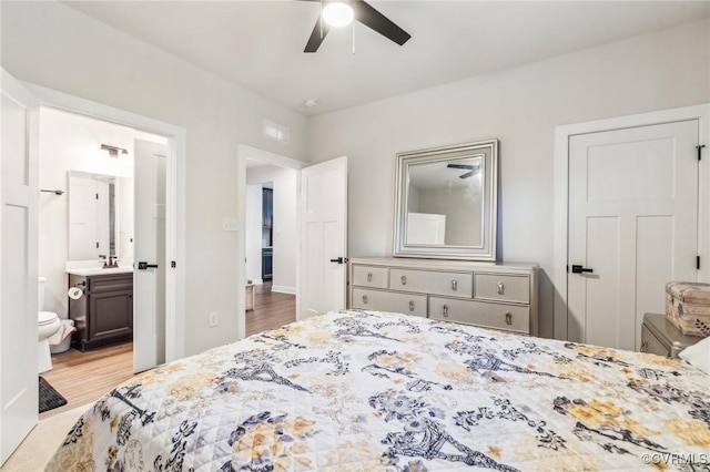 bedroom featuring a sink, visible vents, a ceiling fan, wood finished floors, and connected bathroom