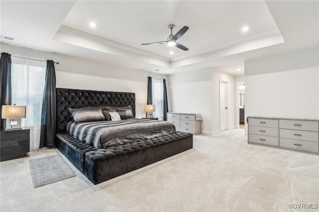bedroom with visible vents, a tray ceiling, recessed lighting, and multiple windows