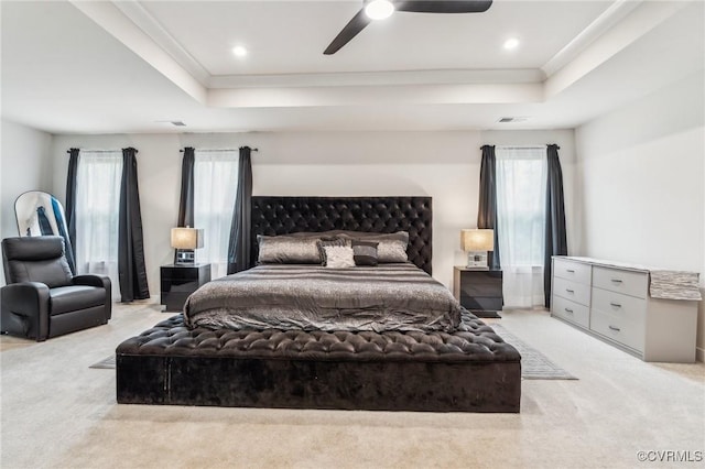 carpeted bedroom featuring crown molding, ceiling fan, a tray ceiling, visible vents, and recessed lighting