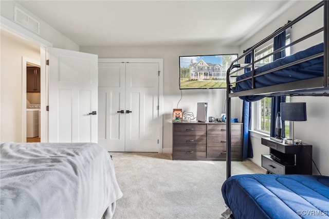 carpeted bedroom with a closet, visible vents, and washer / clothes dryer