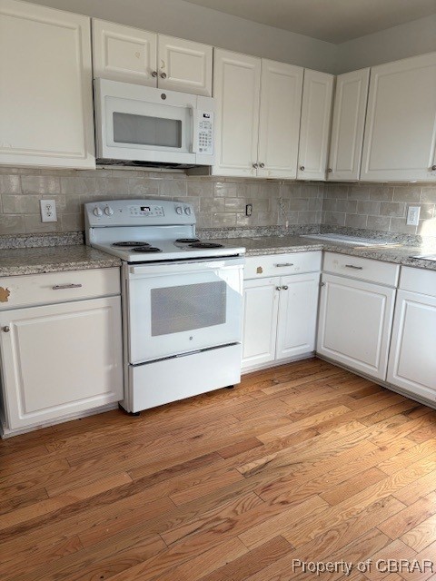 kitchen featuring white cabinets, light wood-type flooring, and white appliances
