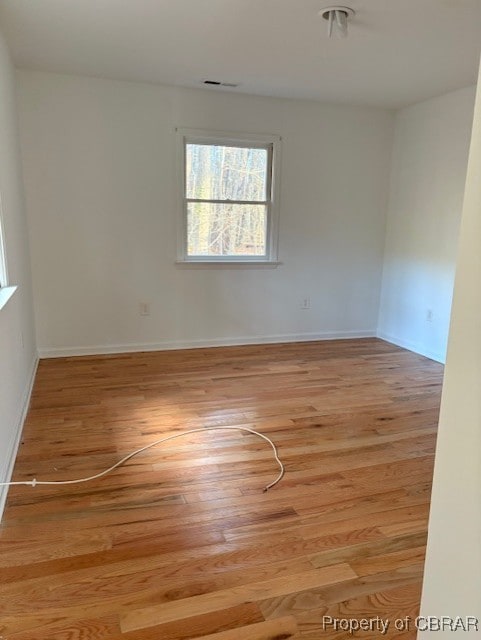 unfurnished room with baseboards and wood finished floors
