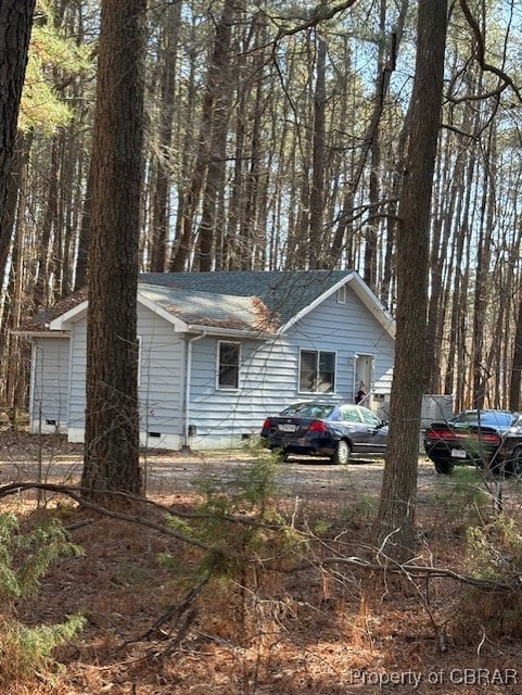 view of front facade with crawl space and roof with shingles