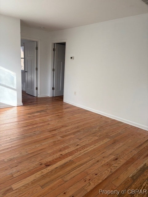 unfurnished room with baseboards and light wood-style floors