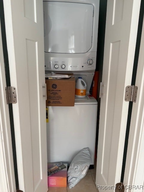 clothes washing area with stacked washer and clothes dryer and laundry area