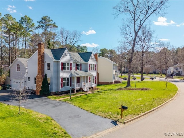 10107 Heritage Ln, Glen Allen, VA 23060 - view of front of property with a chimney, an attached garage, asphalt driveway, a front lawn, and a residential view