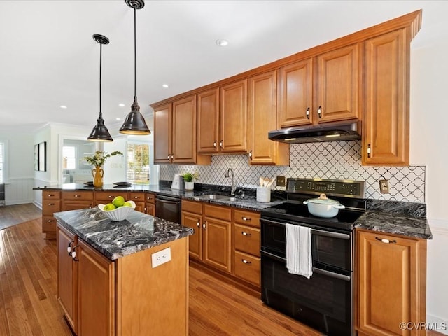 10107 Heritage Ln, Glen Allen, VA 23060 - kitchen with black appliances, under cabinet range hood, wood finished floors, brown cabinets, and recessed lighting