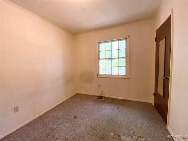 carpeted spare room with visible vents and baseboards