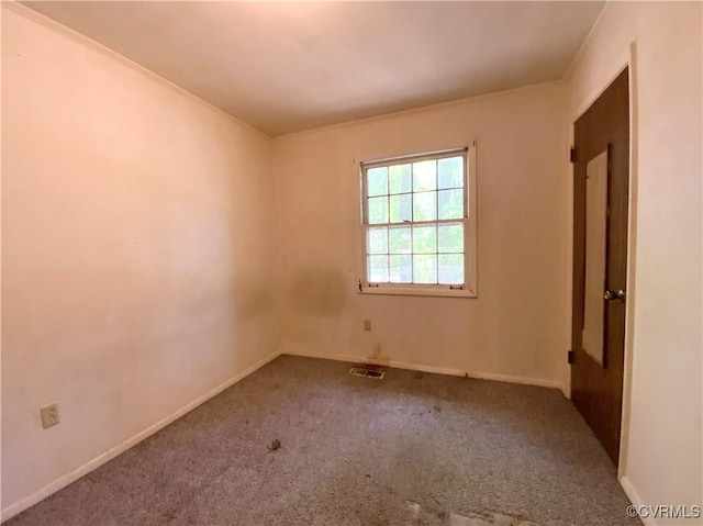 empty room with carpet, visible vents, and baseboards