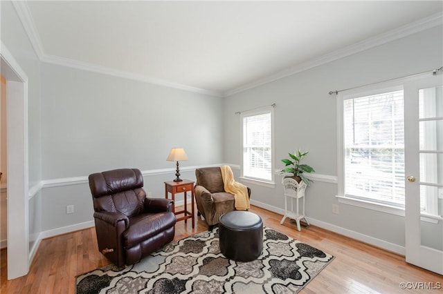 living area featuring baseboards, ornamental molding, and light wood-style flooring