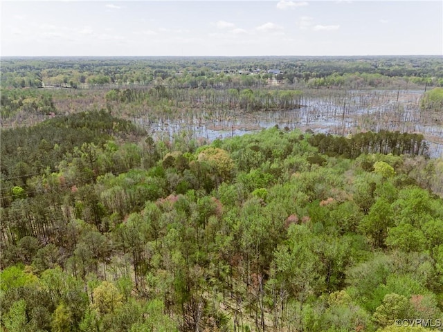 aerial view featuring a wooded view and a water view