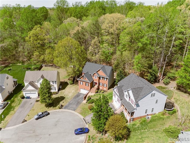 drone / aerial view featuring a forest view and a residential view