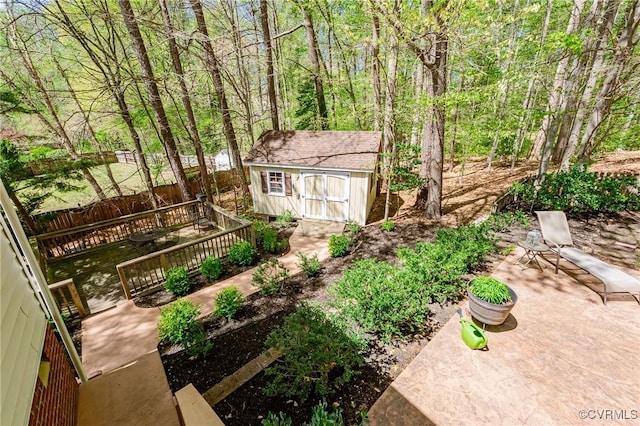 view of yard with an outdoor structure, fence, a patio area, and a shed