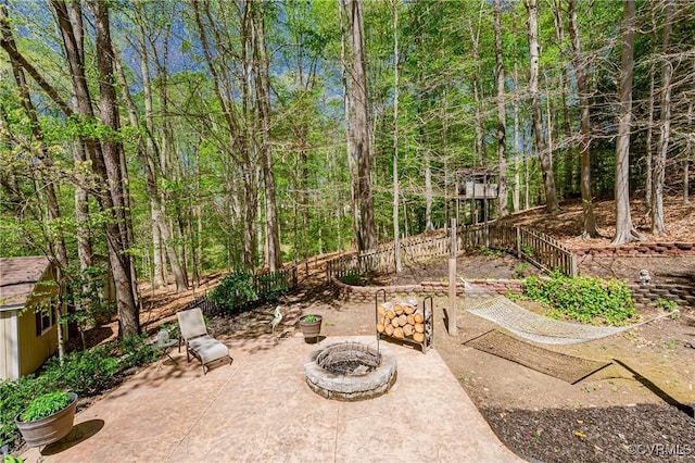 view of patio with fence and a fire pit