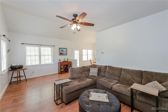 living room with a ceiling fan, lofted ceiling, a healthy amount of sunlight, and light wood-style floors