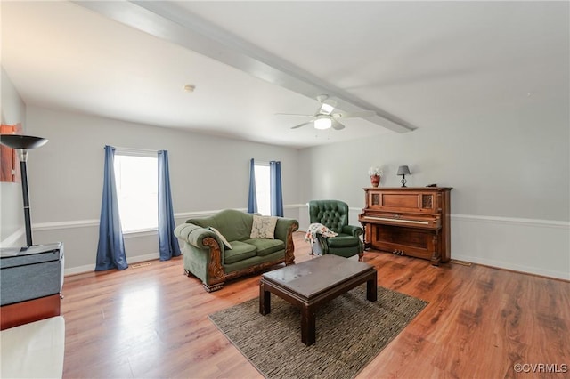 living room featuring ceiling fan, baseboards, and wood finished floors