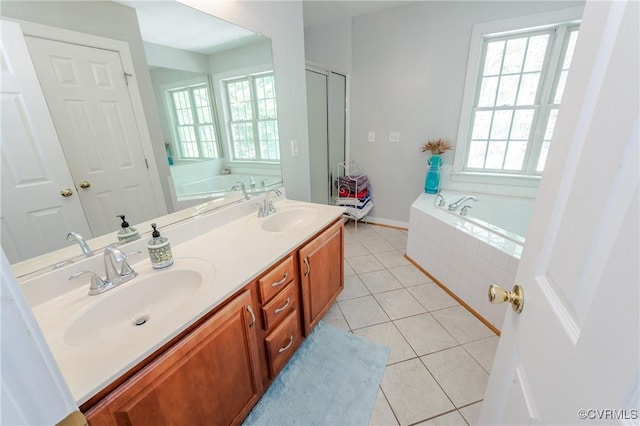 bathroom with tile patterned flooring, a garden tub, a sink, and double vanity