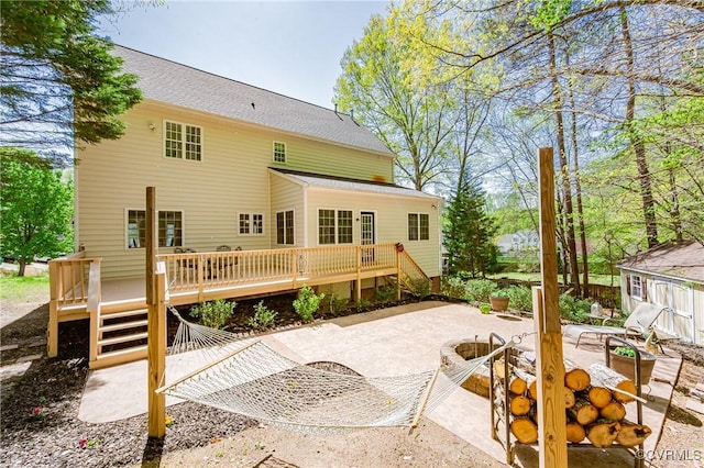 back of house featuring an outdoor fire pit, a deck, and a patio