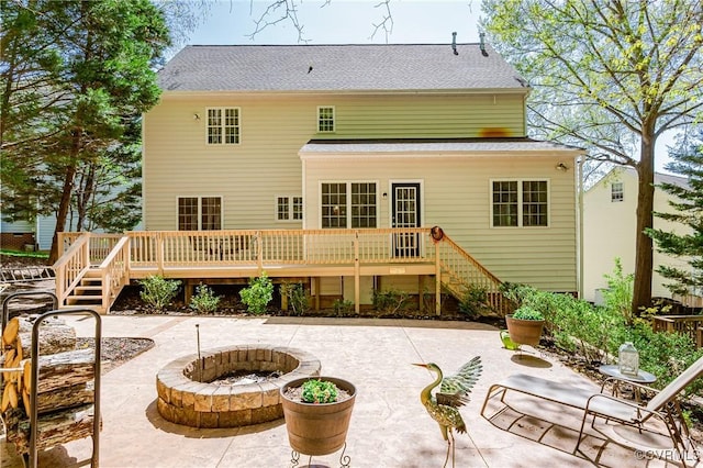 rear view of house featuring stairs, a shingled roof, a patio area, a fire pit, and a deck