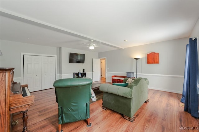 living room with wood finished floors, a ceiling fan, and baseboards