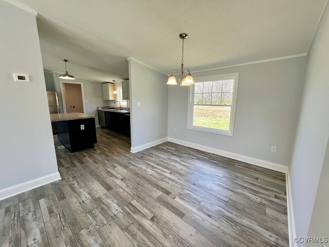 409 Remo Rd, Heathsville, VA 22473 - unfurnished dining area featuring a notable chandelier, ornamental molding, a sink, and dark wood-type flooring