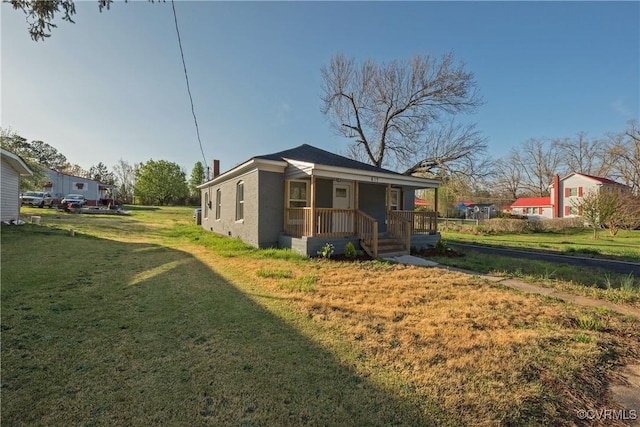 exterior space featuring stucco siding, a porch, and a yard