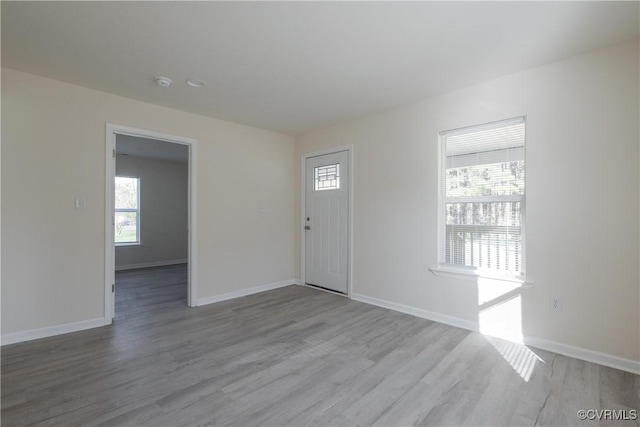 foyer featuring baseboards and wood finished floors