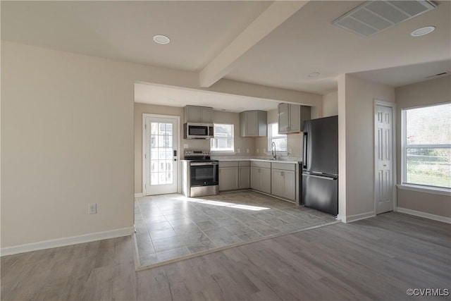 kitchen featuring a wealth of natural light, gray cabinets, visible vents, and stainless steel appliances
