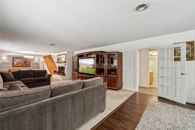8203 Overbury Rd, Richmond, VA 23227 - living area with a warm lit fireplace, a notable chandelier, wood finished floors, and visible vents