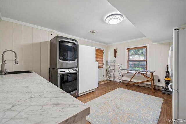 8203 Overbury Rd, Richmond, VA 23227 - kitchen featuring freestanding refrigerator, stacked washer and clothes dryer, a sink, and crown molding