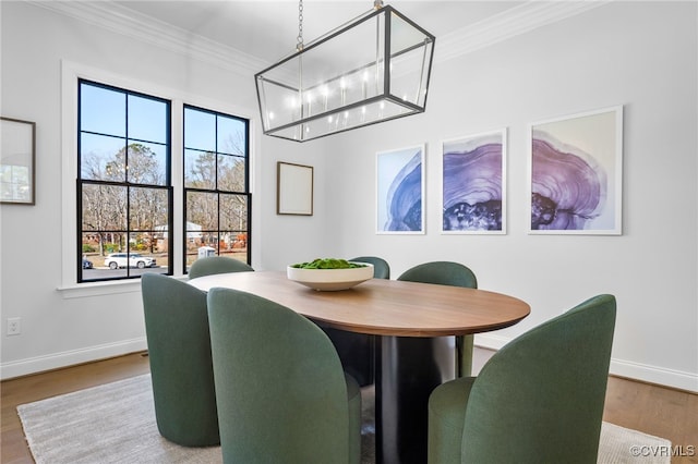 dining area featuring crown molding, wood finished floors, and baseboards