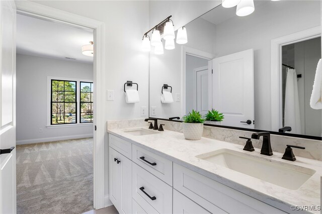 bathroom featuring baseboards, double vanity, and a sink