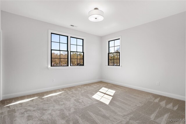 empty room with visible vents, carpet flooring, and baseboards