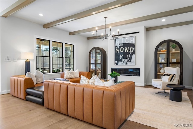 living area featuring light wood finished floors, recessed lighting, beam ceiling, a chandelier, and baseboards