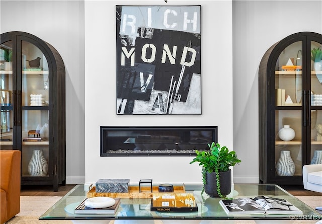 interior space with wood finished floors, arched walkways, and baseboards