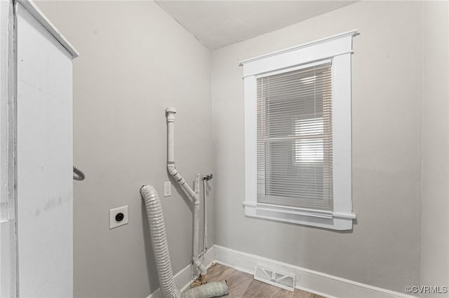 washroom featuring wood finished floors, hookup for an electric dryer, laundry area, baseboards, and visible vents