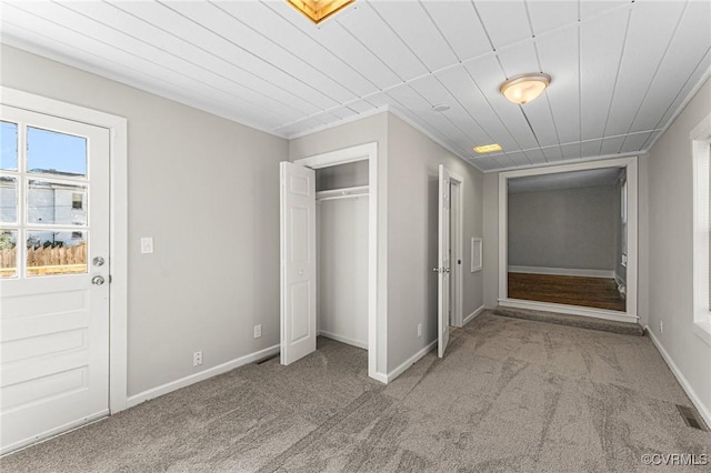unfurnished bedroom featuring a closet, carpet, baseboards, and visible vents