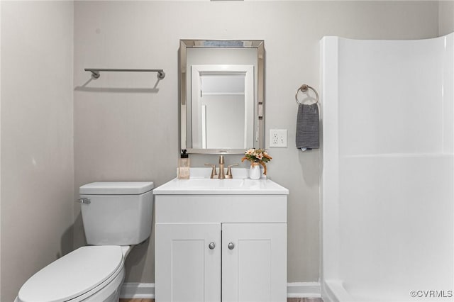 full bathroom featuring baseboards, toilet, a shower, and vanity