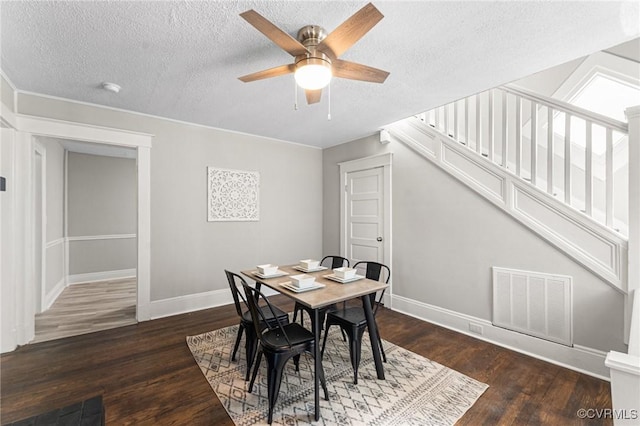 dining area featuring stairs, a ceiling fan, dark wood-style floors, baseboards, and visible vents